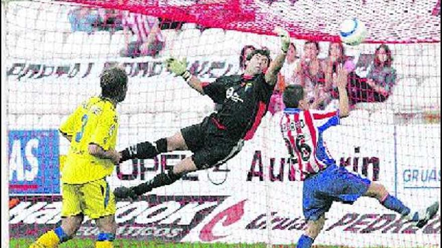 Armando despeja un balón durante un partido en El Molinón, ante Gerardo y Raúl López.