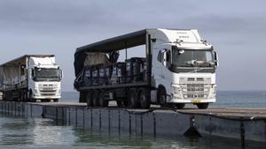 Camiones cargados con ayuda humanitaria cruzan el muelle flotante hacia la Franja de Gaza