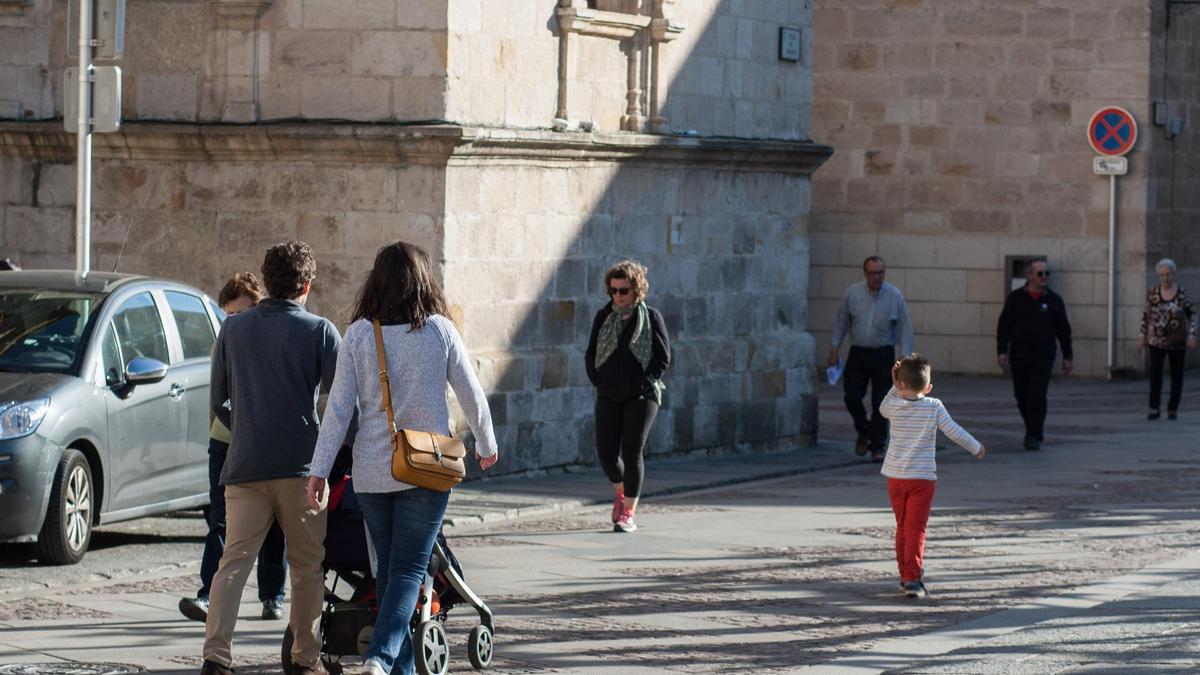 Padres paseando  a su bebé por la calle.