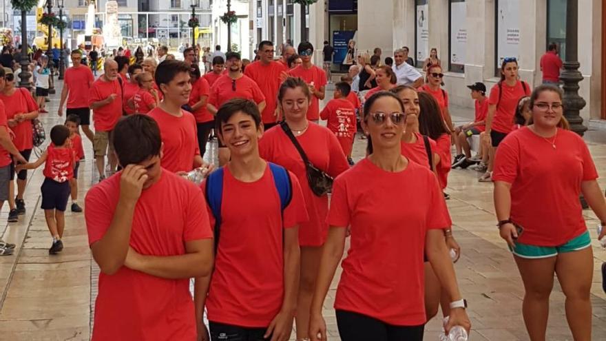 Los participantes en la caminata solidaria, a su paso por la calle Larios.