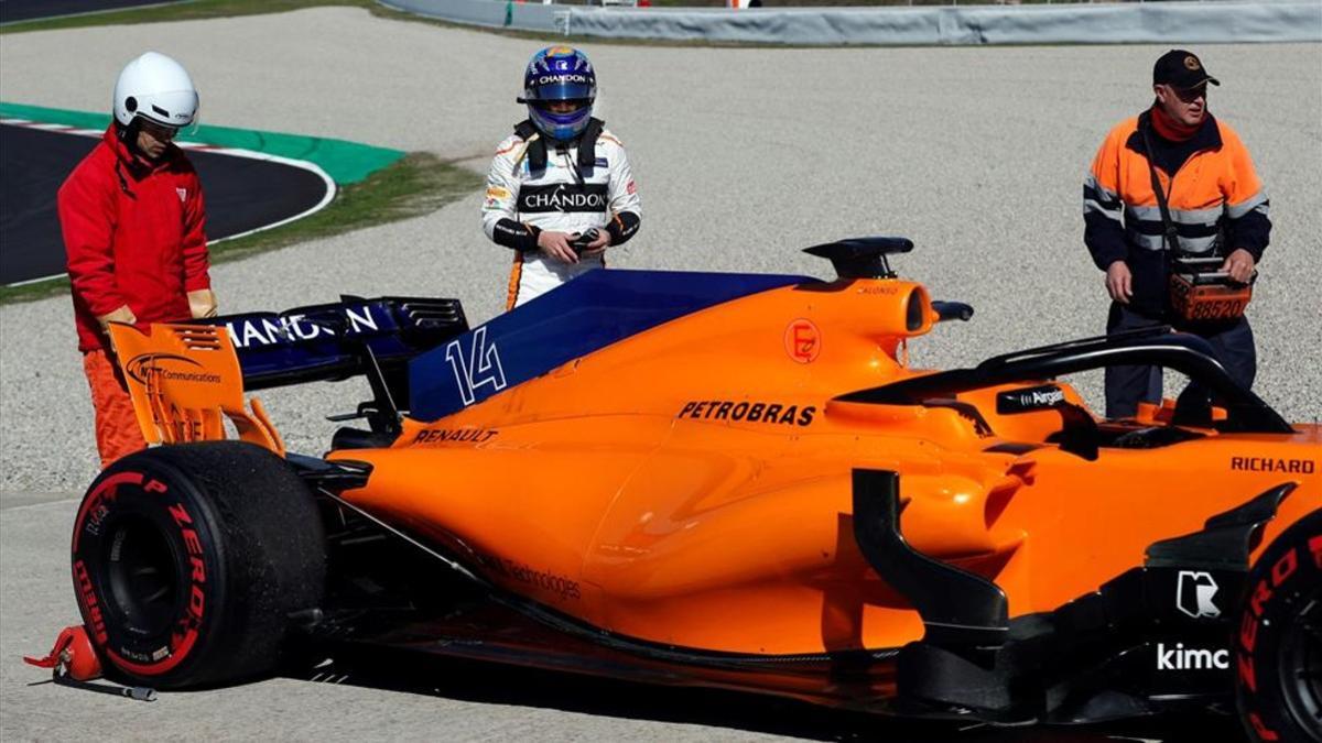Alonso observa el coche tras una problema mecánico que le ha dejado fuera