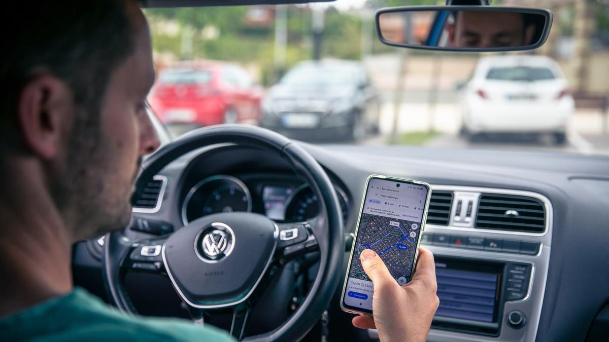 Una persona utilitzant el mòbil mentre condueix.