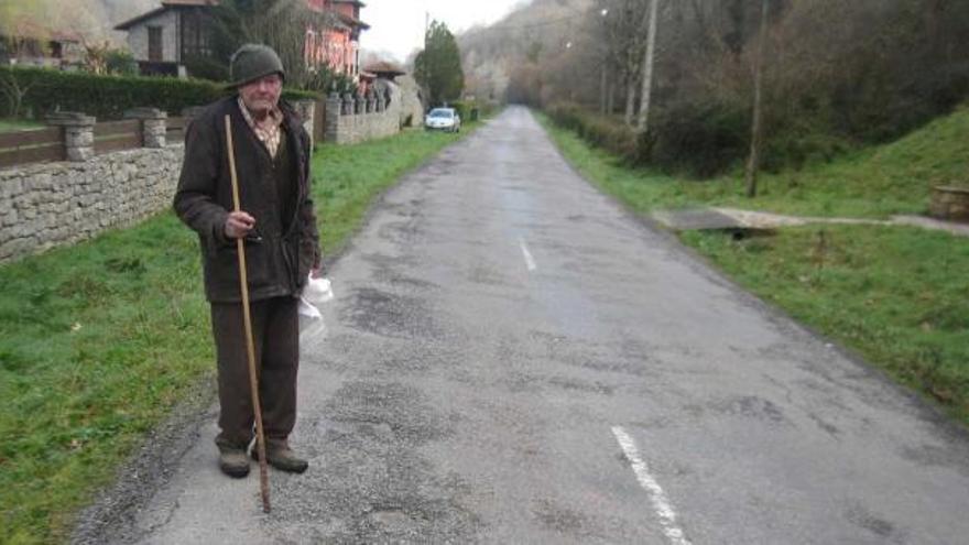 Federico Sierra, vecino de Vegarrionda, muestra los baches de la carretera AS-254 a su paso por la localidad.