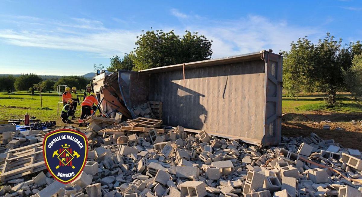 Camionero atrapado tras volcar su vehículo cargado de material de construcción