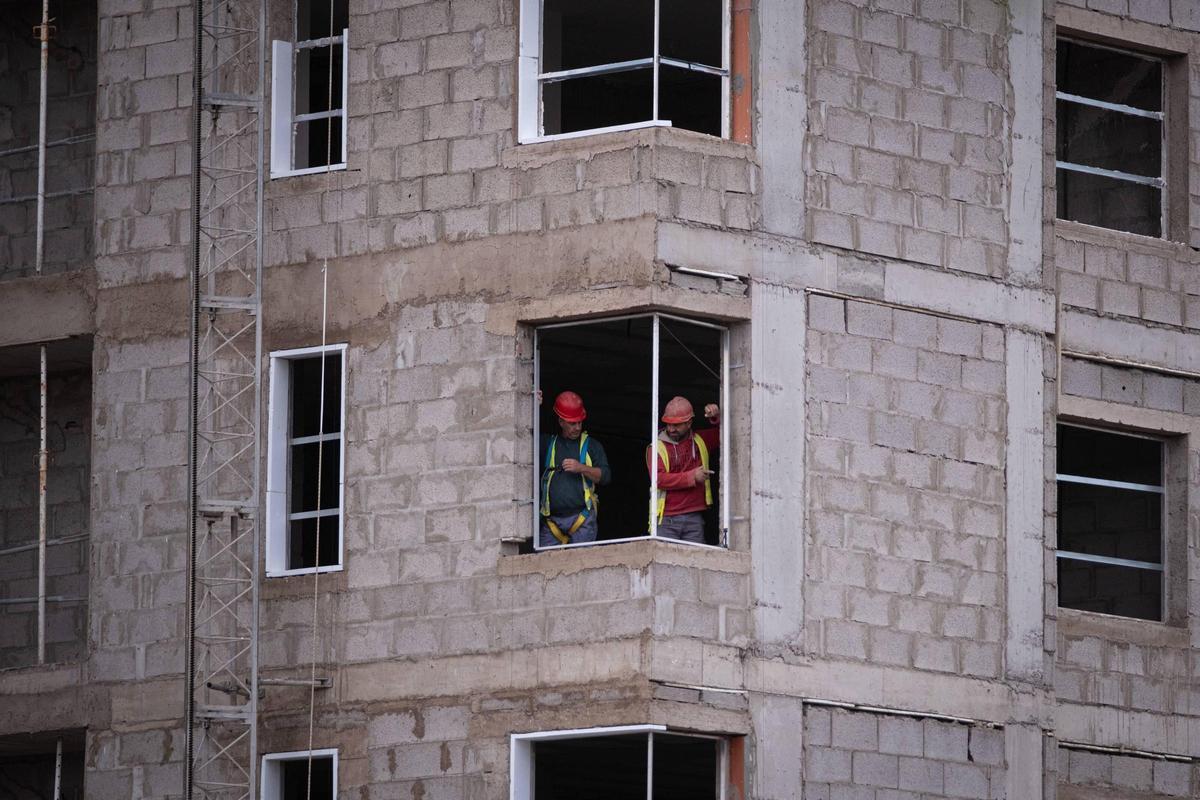 Unos obreros trabajan en la construcción de viviendas.