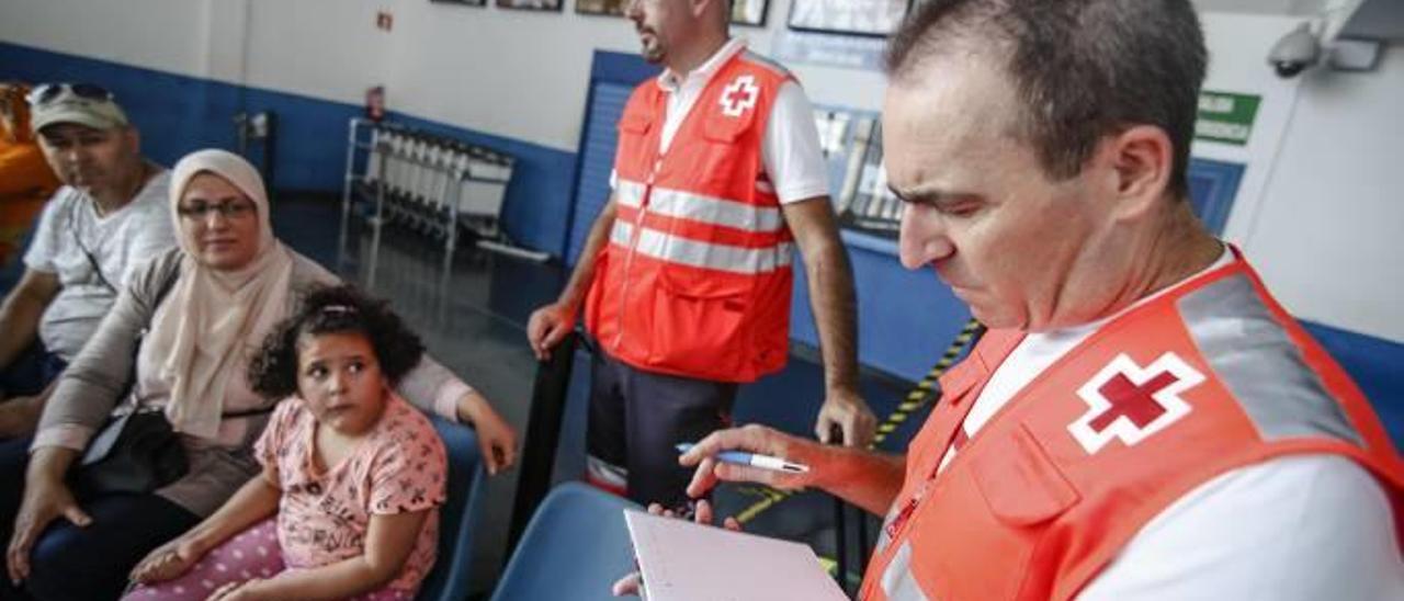 Voluntarios de Cruz Roja atienden a una familia argelina en el puerto.