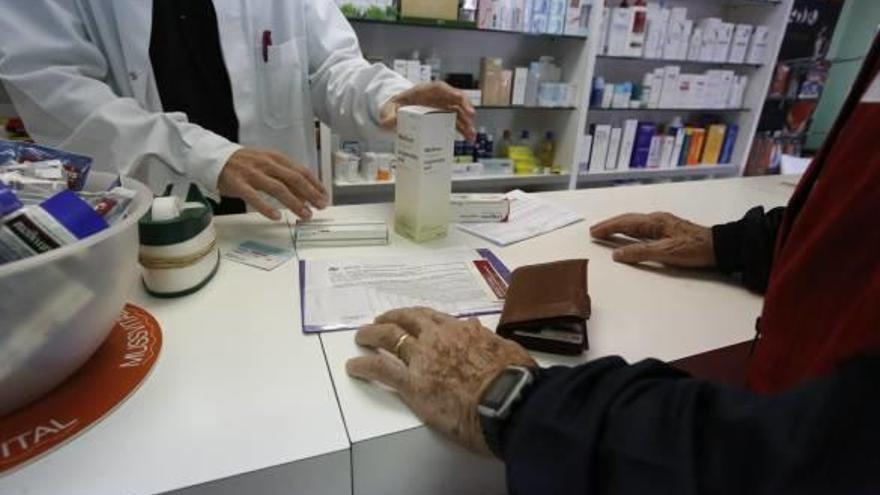 Una persona mayor recoge medicamentos en una farmacia de Alicante, en una imagen de archivo.