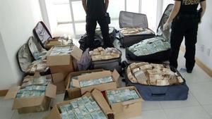 Maletas y cajas con enormes fajos de billetes de la divisa brasileña, en el piso registrado por la policía, en Salvador de Bahía, el 5 de septiembre.