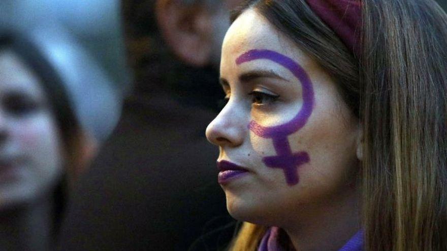 Una mujer con la cara pintada en una manifestación del 8M.