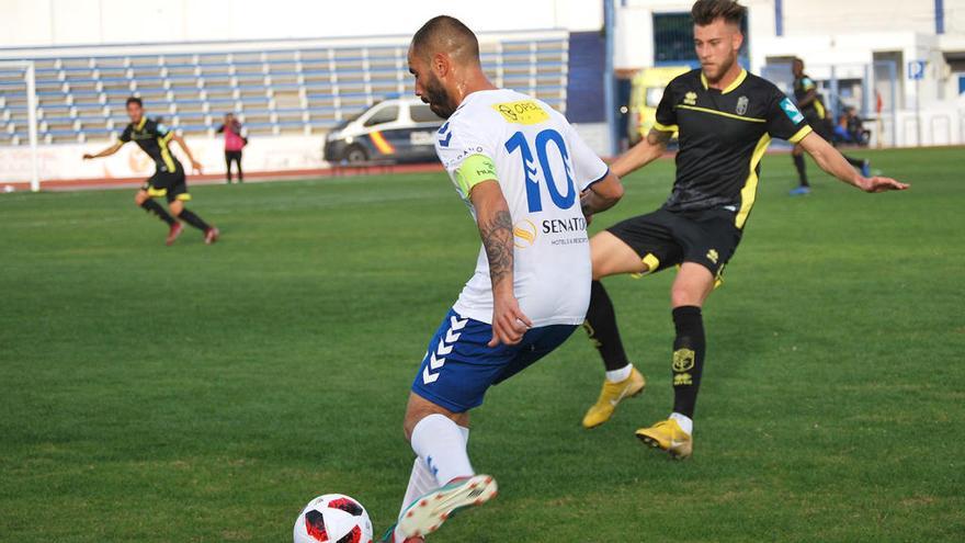 El capitán blanquillo, Javier Añón, conduce el esférico ante un jugador granadinista.