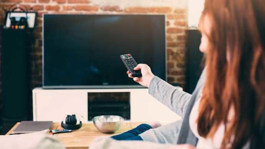 Una mujer viendo la televisión.