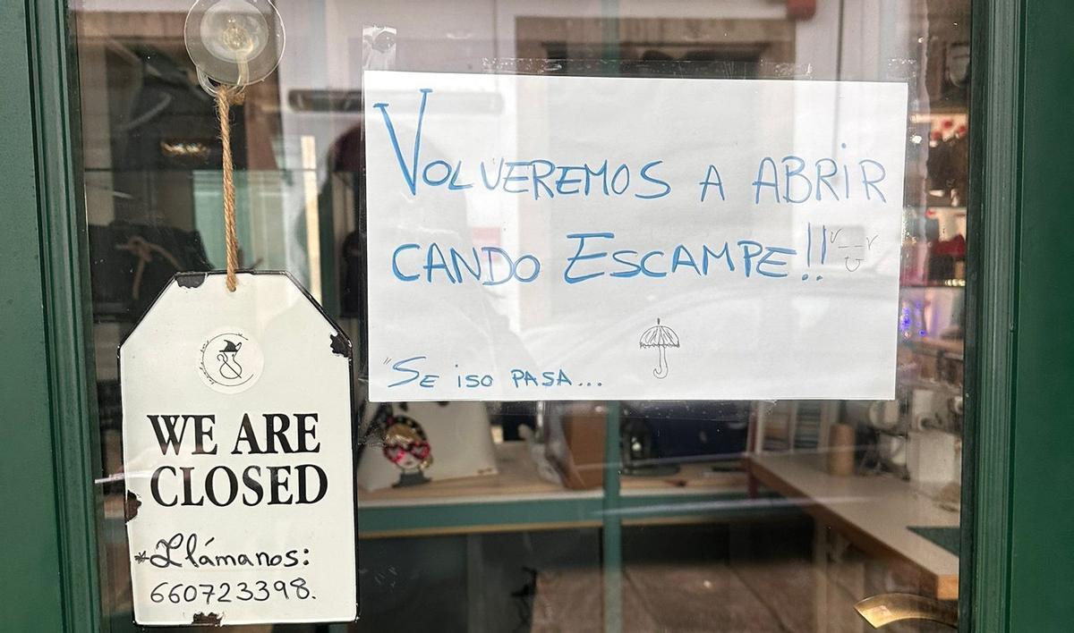 El cartel de la tienda, anunciando su cierre por lluvias.