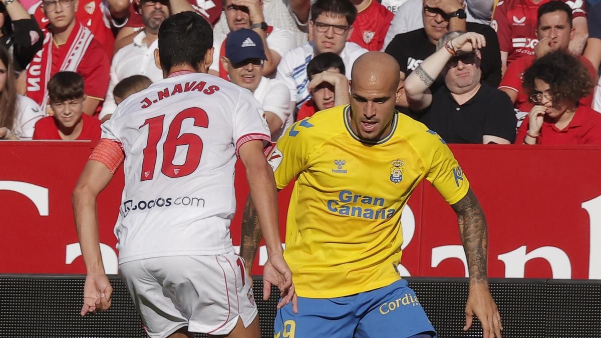 Sandro Ramírez conduce el balón ante la mirada de Jesús Navas, del Sevilla