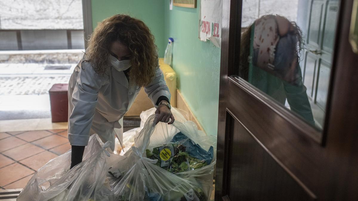 Una trabajadora de Cáritas organiza las bolsas de ensalada,