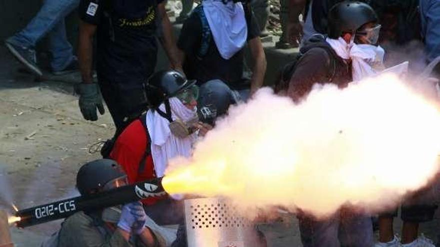Opositores disparan voladores a los policías en Caracas.  // Reuters