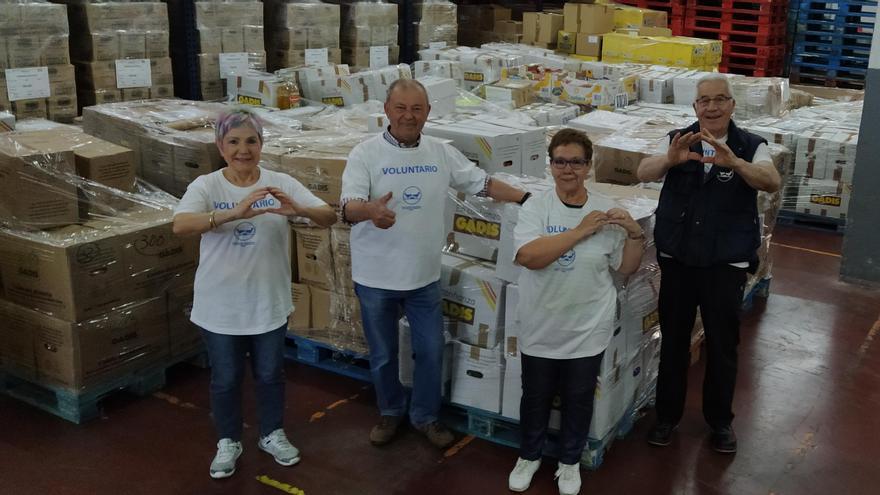 Voluntarios con gran parte de los alimentos recogidos en la nave de la entidad.