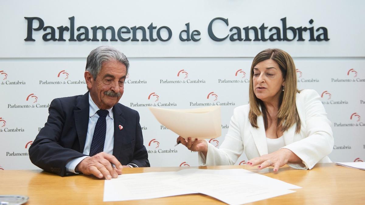 El secretario general del PRC, Miguel Ángel Revilla, y la presidenta del PP, María José Sáenz de Buruaga, firman el acuerdo que permitirá la investidura de ésta última como presidenta de Cantabria.