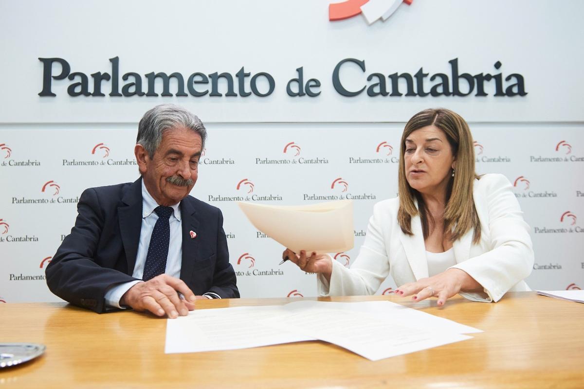 El secretario general del PRC, Miguel Ángel Revilla, y la presidenta del PP, María José Sáenz de Buruaga, firman el acuerdo que permitirá la investidura de ésta última como presidenta de Cantabria.
