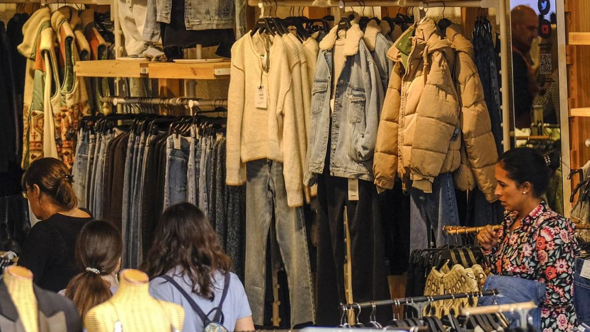 Cuatro mujeres realizan compras en una tienda de ropa. | |