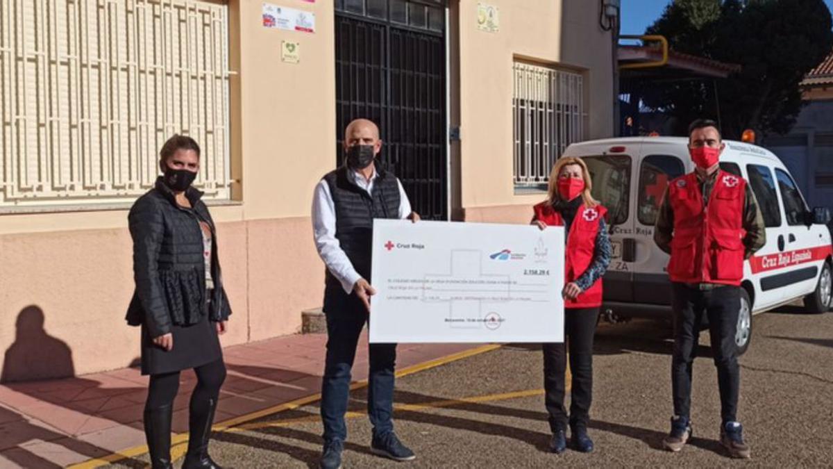 Representantes del colegio Virgen de la Vega de Benavente y de Cruz Roja en el acto de entrega del cheque. | E. P.