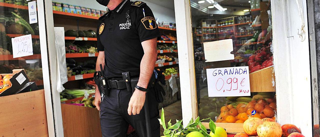 Un agente de la Policía Local abandona una frutería tras haber inspeccionado el género. | MATÍAS SEGARRA