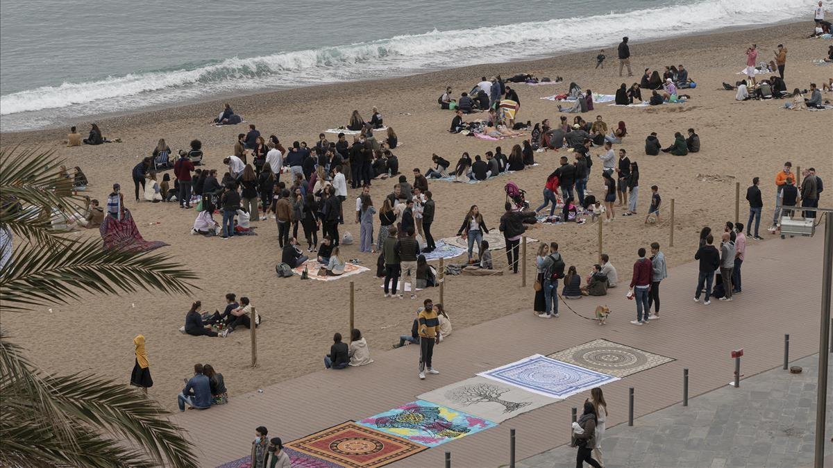 Playa de la Barceloneta por la tarde, donde numerosos jóvenes quedan para tomar algo sobre la arena.