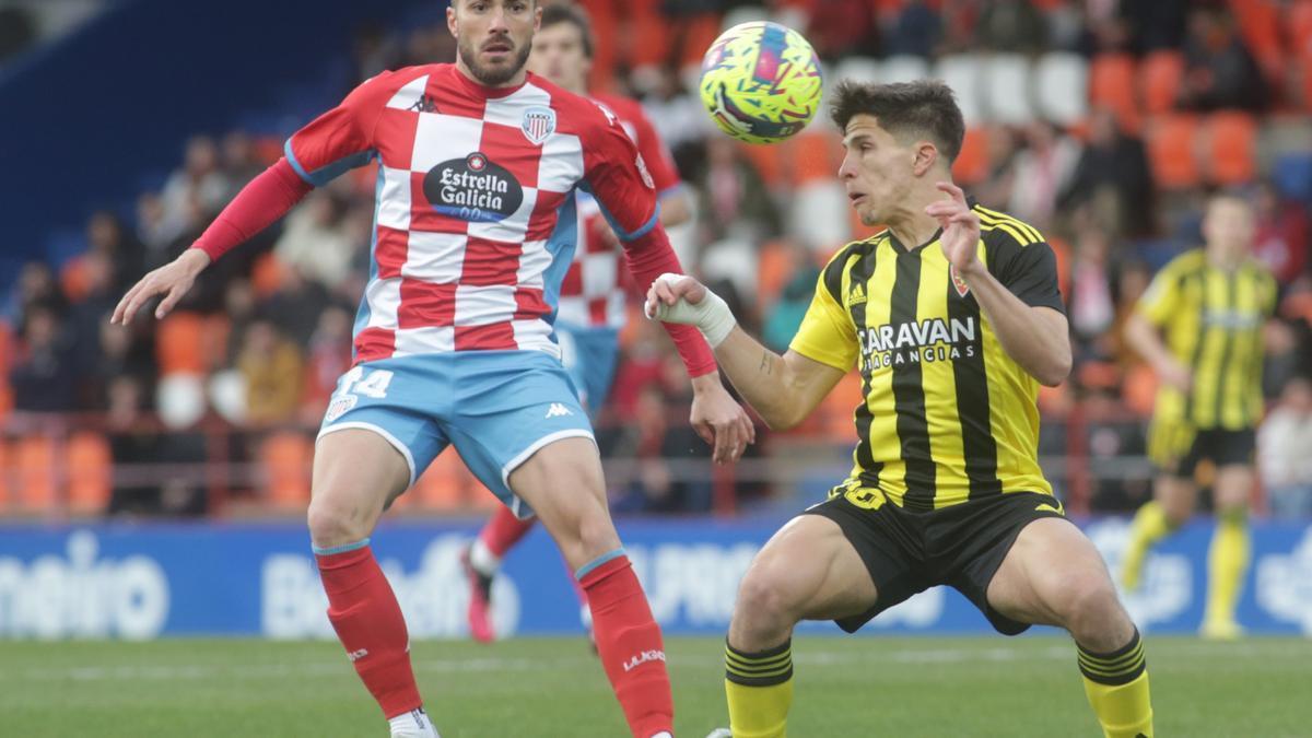 Giuliano Simeone intenta llevarse un balón de cabeza ante Xavi Torres.