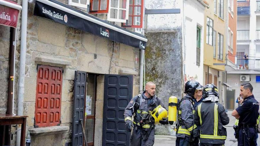 Policía Nacional con efectivos de Bomberos en un reciente incendio en un bar de Vilagarcía. // Iñaki Abella