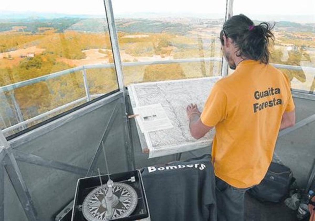 Un guaita consulta un mapa des de la torre de vigilància d’incendis forestals de Santa Maria de Merlès. Un guaita consulta un mapa des de la torre de vigilància d’incendis forestals de Santa Maria de Merlès.