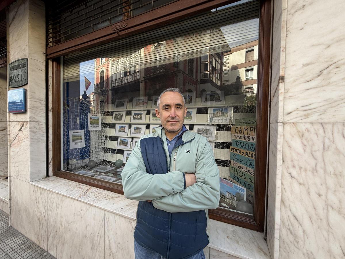 José Ramón Campillo junto al escaparate de la sede de su inmobiliaria, en Llanes.