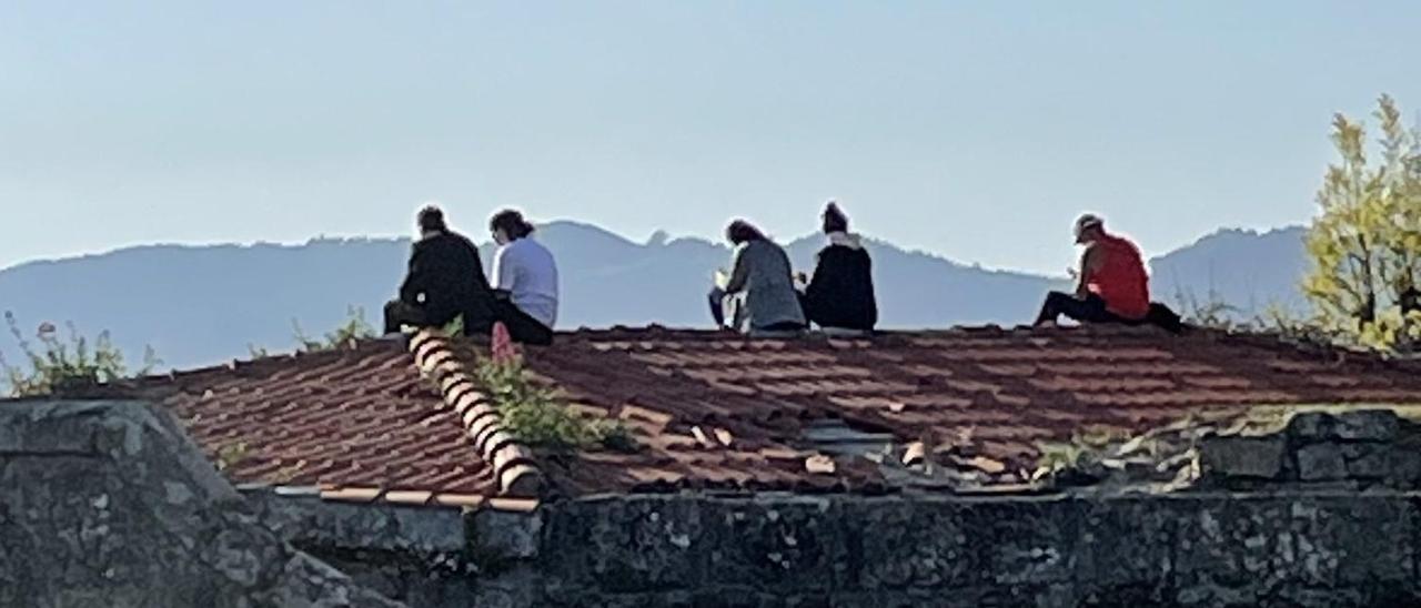 Personas subidas al peligroso mirador sobre la ría de Vigo.