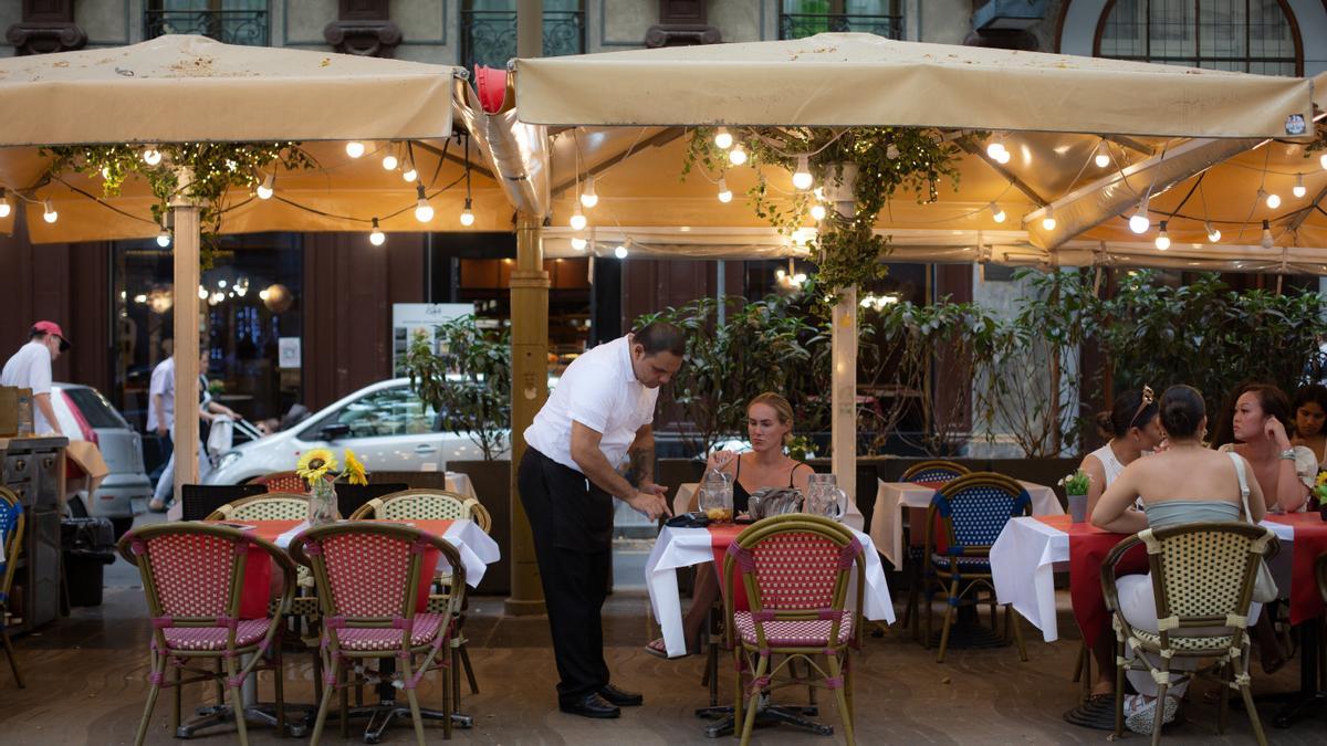 Un camarero atiende una mesa en un restaurante.