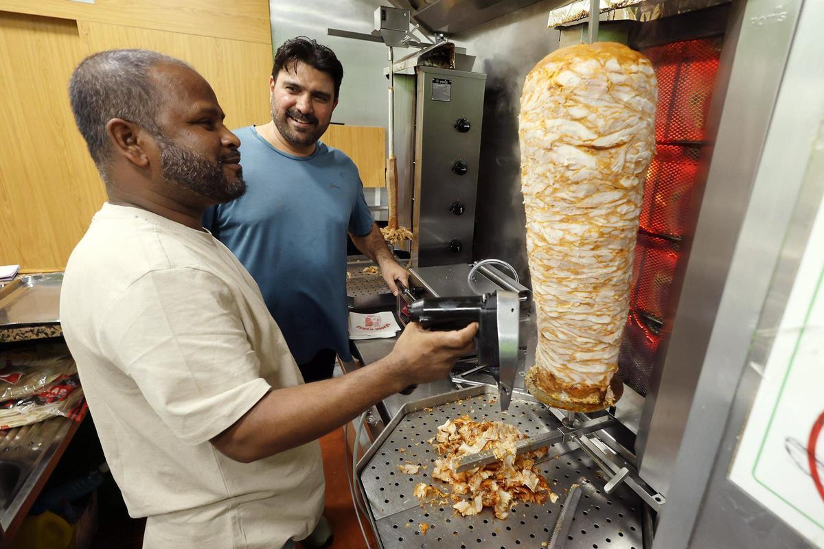 Yasir trabaja junto a uno de los empleados del kebab.