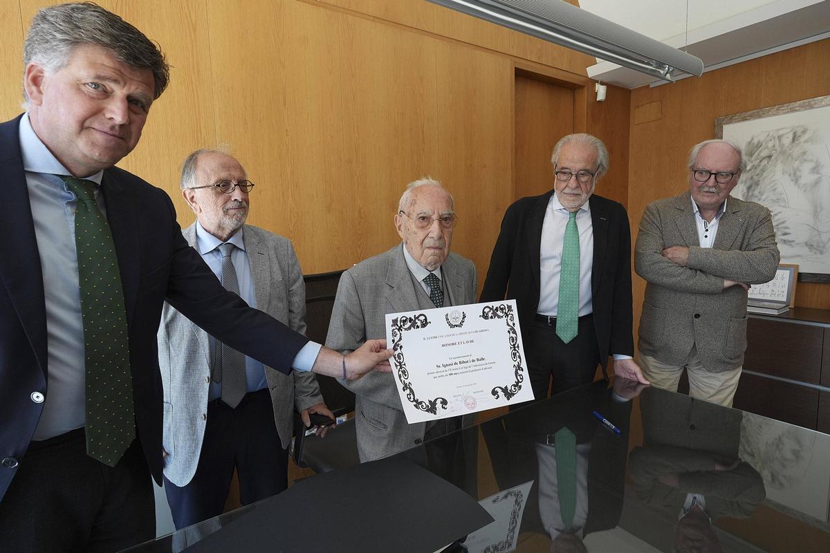 El degà del Col·legi de l’Advocacia de Girona mostrant el diploma que han entregat a l'homenatjat Ignasi de Ribot, al centre de la imatge.