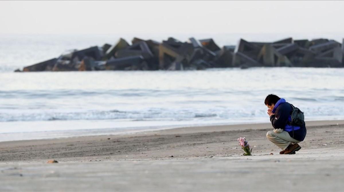 vvargas42470689 a man prays after offering flowers in arahama coastal area w180311100651