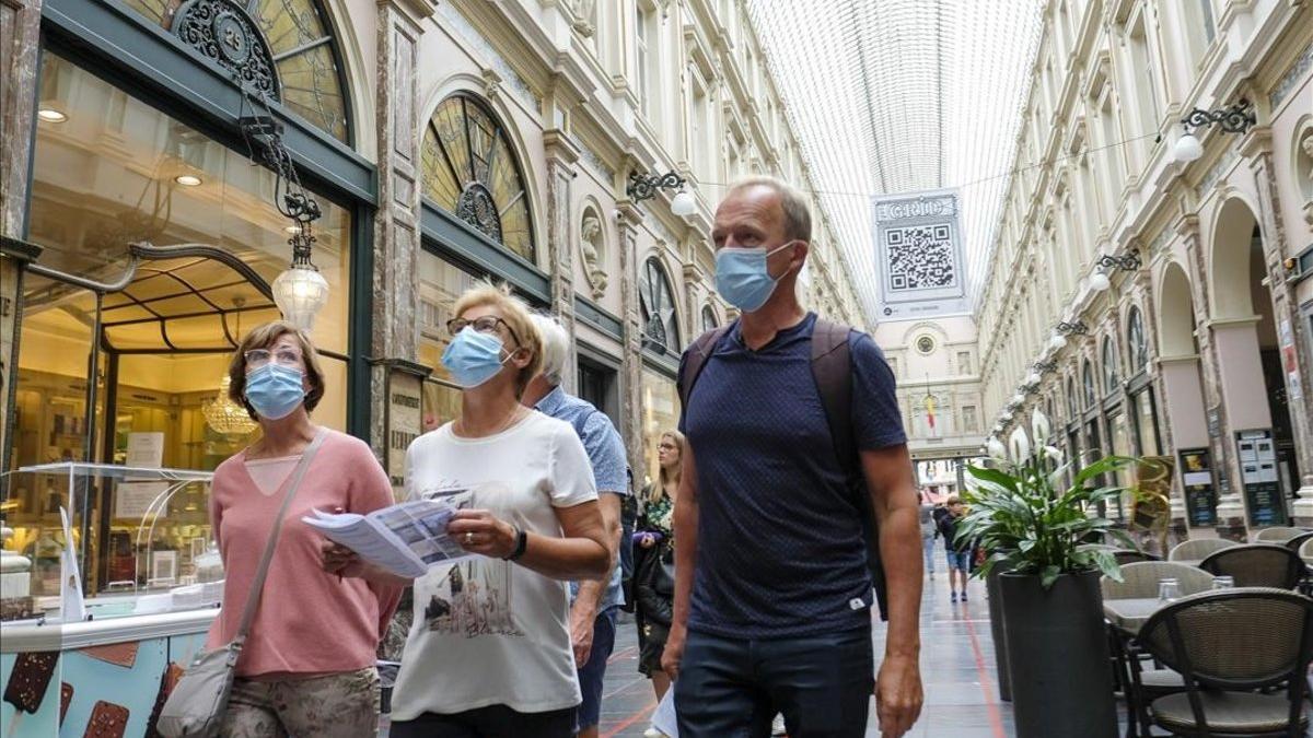 Paseantes con mascarilla por el centro de Bruselas