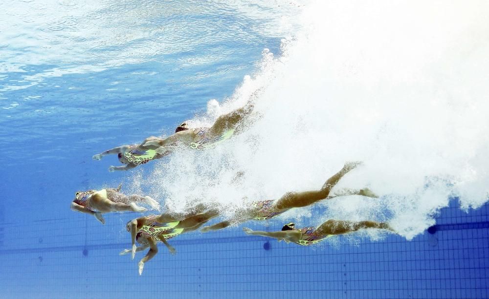 Las niponas de natación sincronizada se zambullen bajo el agua.