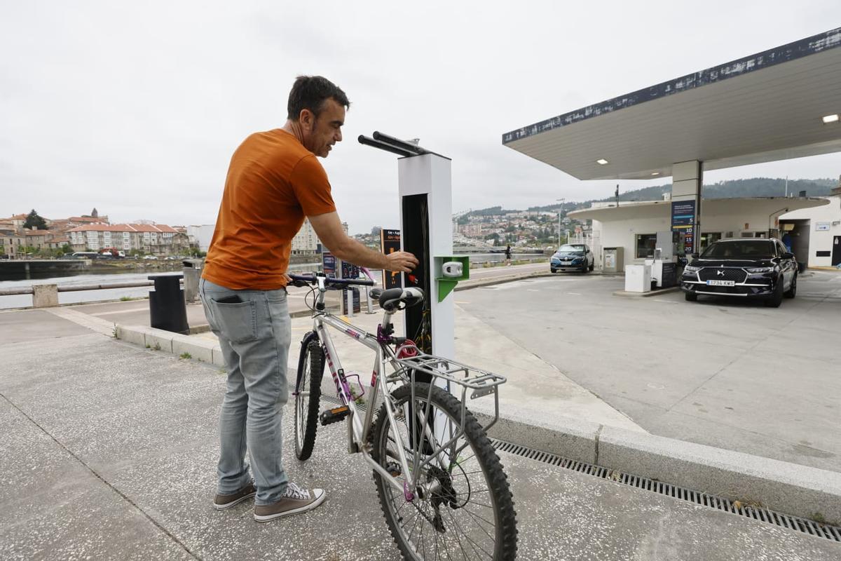 El concelleiro, Xaquín Moreda, utilizando la nueva estación pública de reparación e inflado de bicicletas
