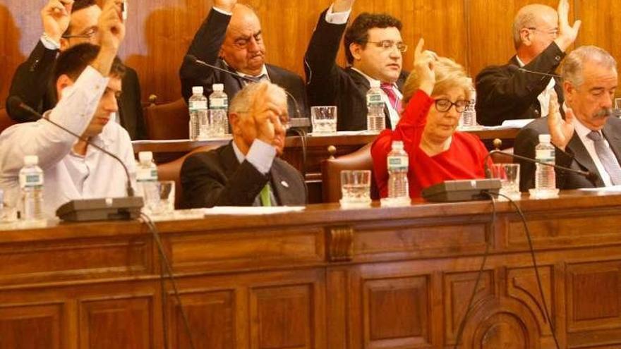 Diputados alzan la mano durante una votación.