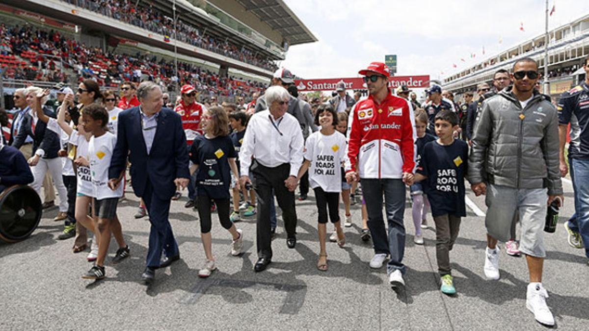 Todt (con traje), Ecclestone (centro), Alonso y Hamilton, durante el acto para promocionar la seguridad vial celebrado en Montmeló