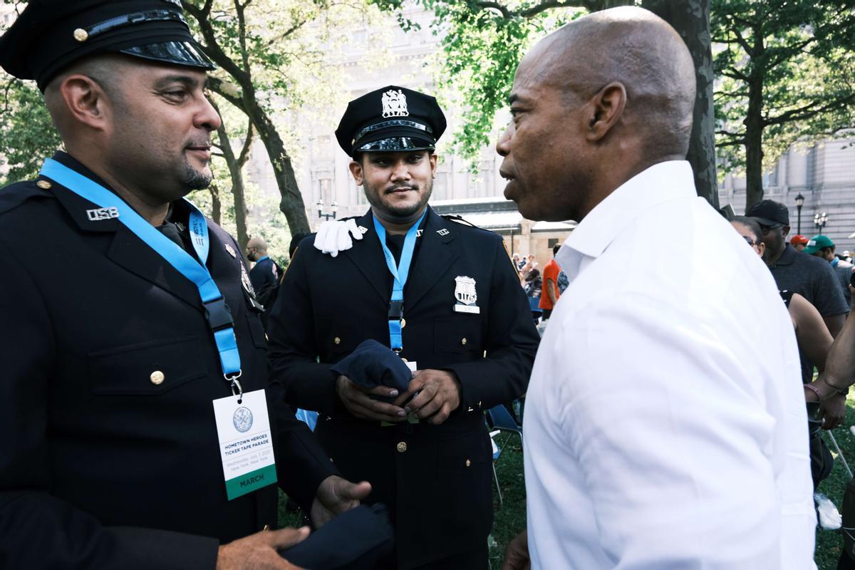 Adams conversa con dos agentes en un acto con policías, bomberos y trabajadores sanitarios, el pasado 7 de julio en Nueva york.