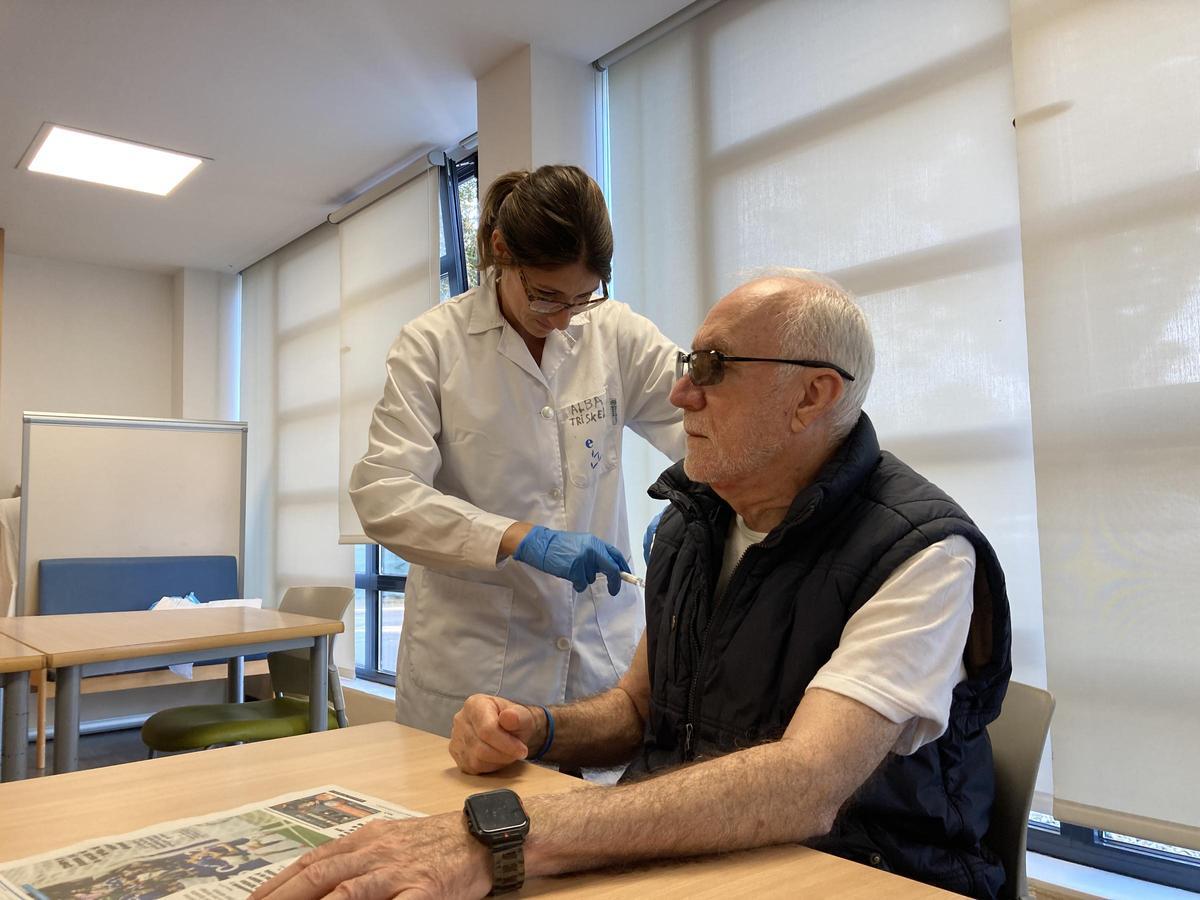 Humberto Hora receives the flu and covid vaccine. Alba Arenas puts it on, care coordinator in El Trisquel