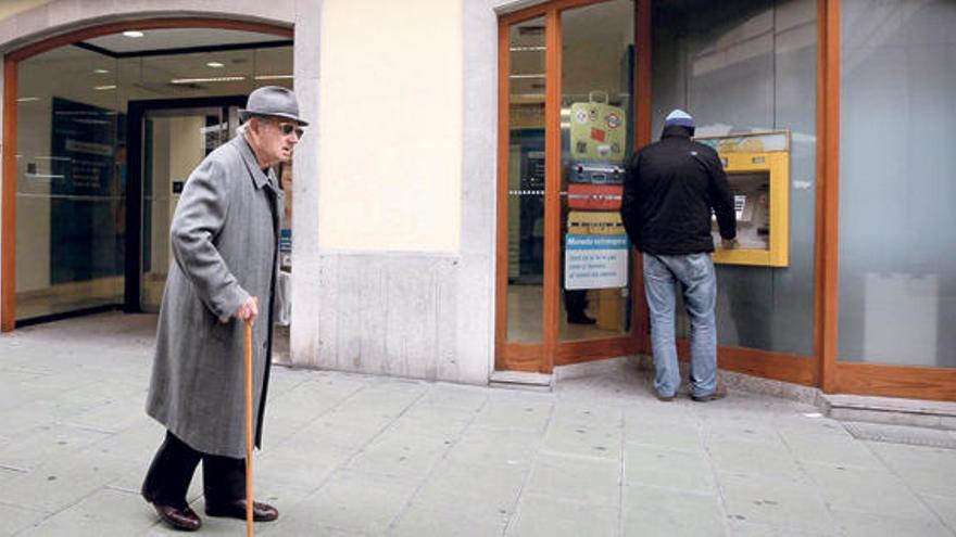 Un anciano pasea ante un cajero automático en Palma. Las salidas de las bancos son un lugar propicio para que los mayores sufran robos violentos.