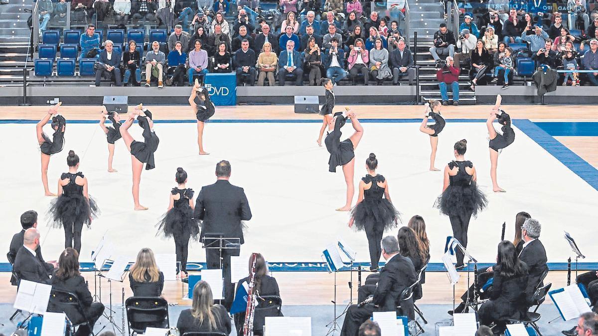 Las bailarinas en la pista del Palacio de los Deportes junto a los músicos de la Banda de Música «Ciudad de Oviedo».