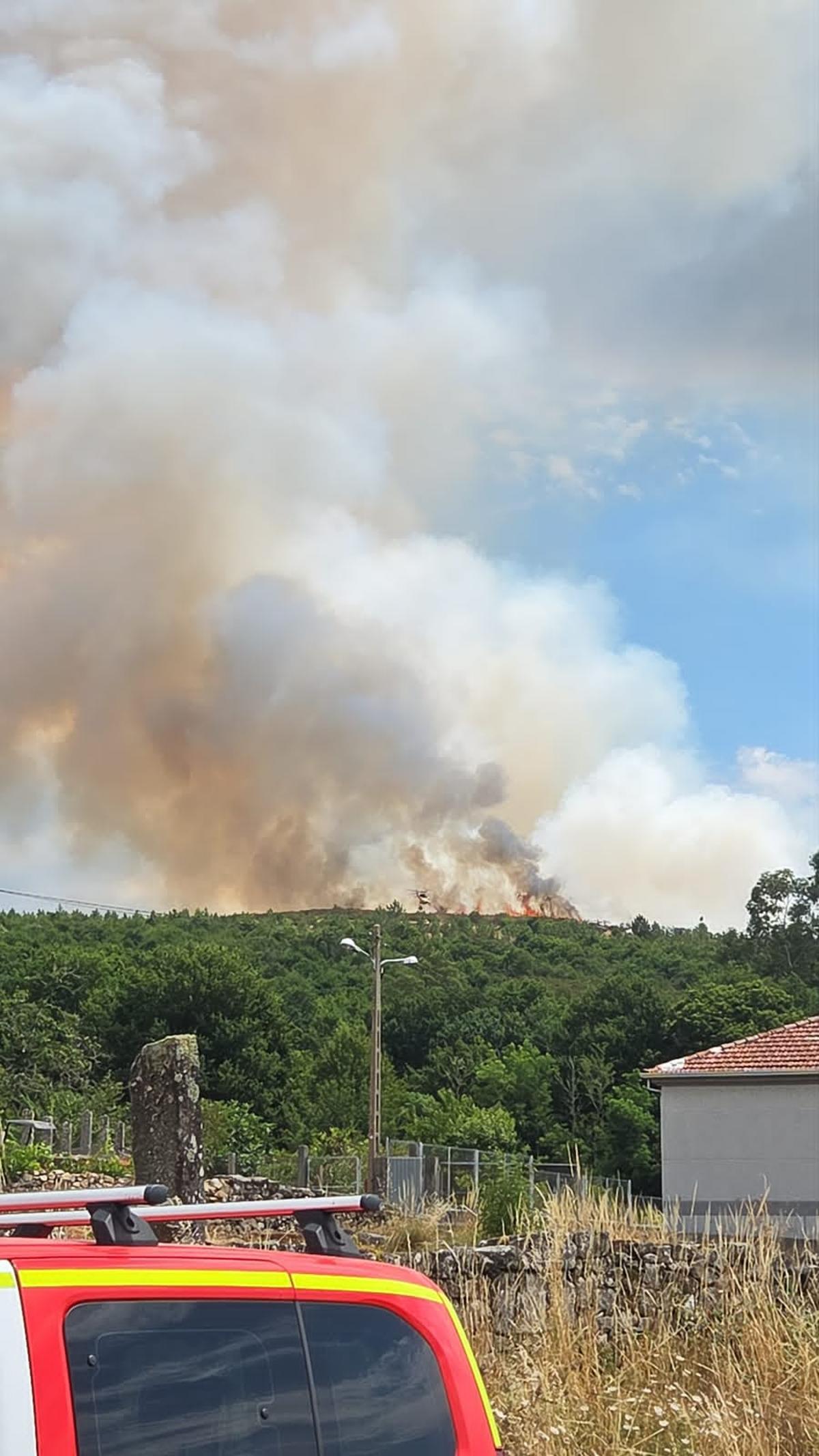 Los medios aéres combatiendo las llamas que recorren el monte.
