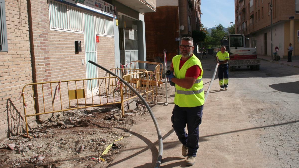 Dos obreros durante las tareas que llevan a cabo en la renovación urbana de la calle Molins de Rei.
