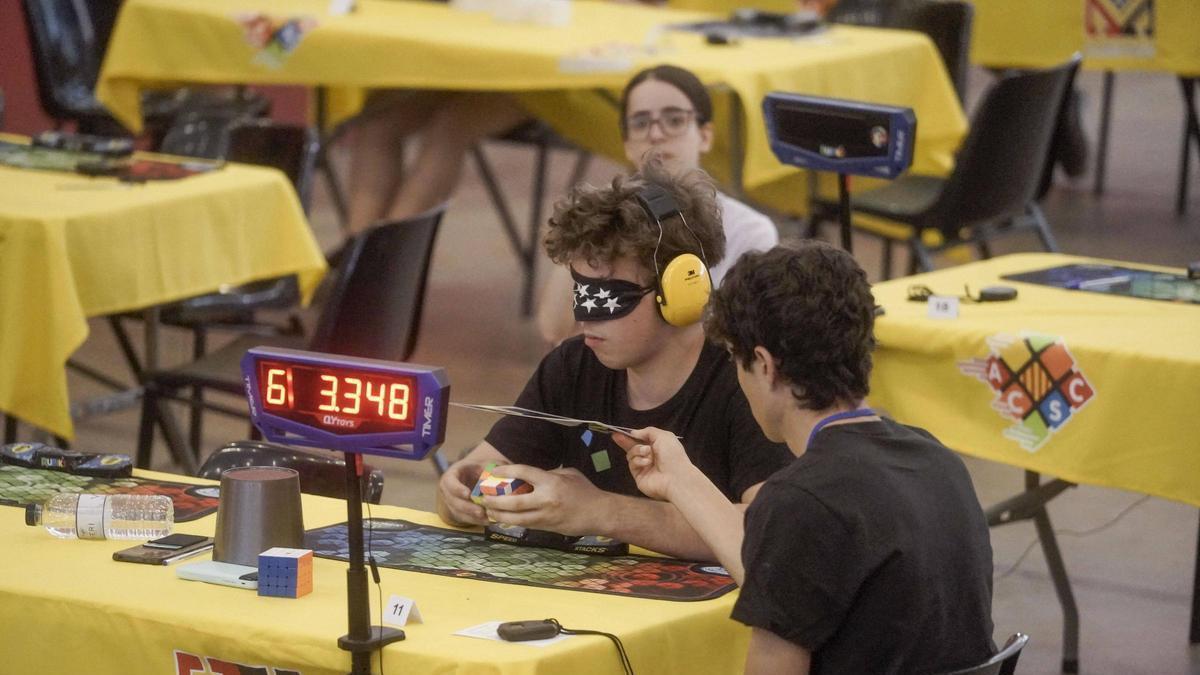 Un competidor amb els ulls tapats intenta resoldre un cub de 4 daus de costat