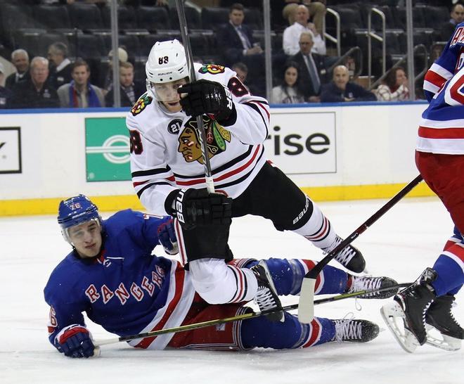 Brady Skjei # 76 de los New York Rangers derrota a Patrick Kane # 88 de los Chicago Blackhawks durante el primer período en el Madison Square Garden.