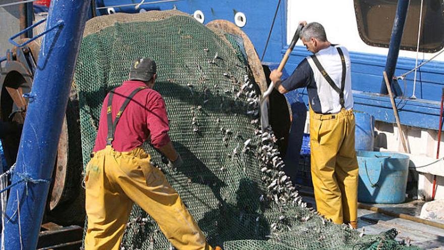 Pescadors de Llançà preparant les xarxes per sortir a feinejar.