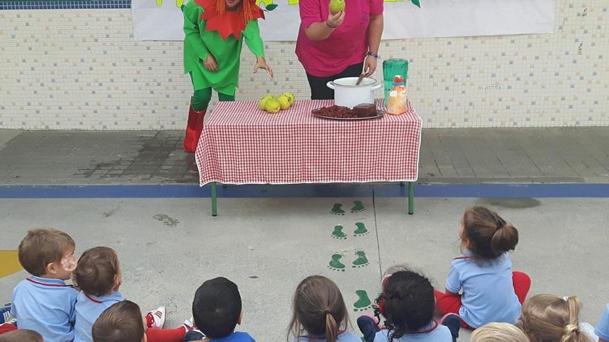 Laura Vela muestra los membrillos a los pequeños alumnos.